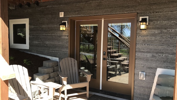 Ein Außenbereich mit Adirondack-Stühlen und einer Holzterrasse.