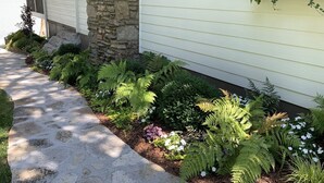 A stone pillar, a pathway, and a variety of plants including ferns and flowers. - Bluebird Rest - Peaceful Lake Retreat (Kelso)