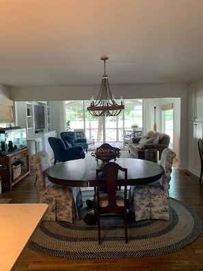 Relax in this inviting living space with a round dining table, comfortable seating area, and a large window offering a view of the outdoors.