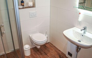 A bathroom with a toilet, a sink, and a shower.