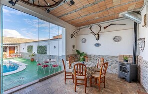 Un espace repas avec vue sur une piscine, une cheminée et des décorations en forme de bois de cerf.