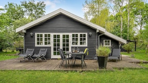 A log cabin with a deck, outdoor seating, and a garden. - 3 bedroom amazing home in Glesborg (Glesborg)