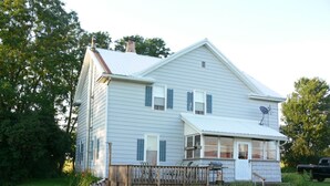 A two-story house with a covered porch, a satellite dish, and a fenced yard. - Lever Hill Lodge (Andover)