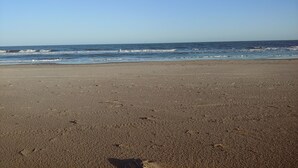 A beach with a clear sky and calm sea. - Rica Rico - Beach View Getaway (Grand Isle)