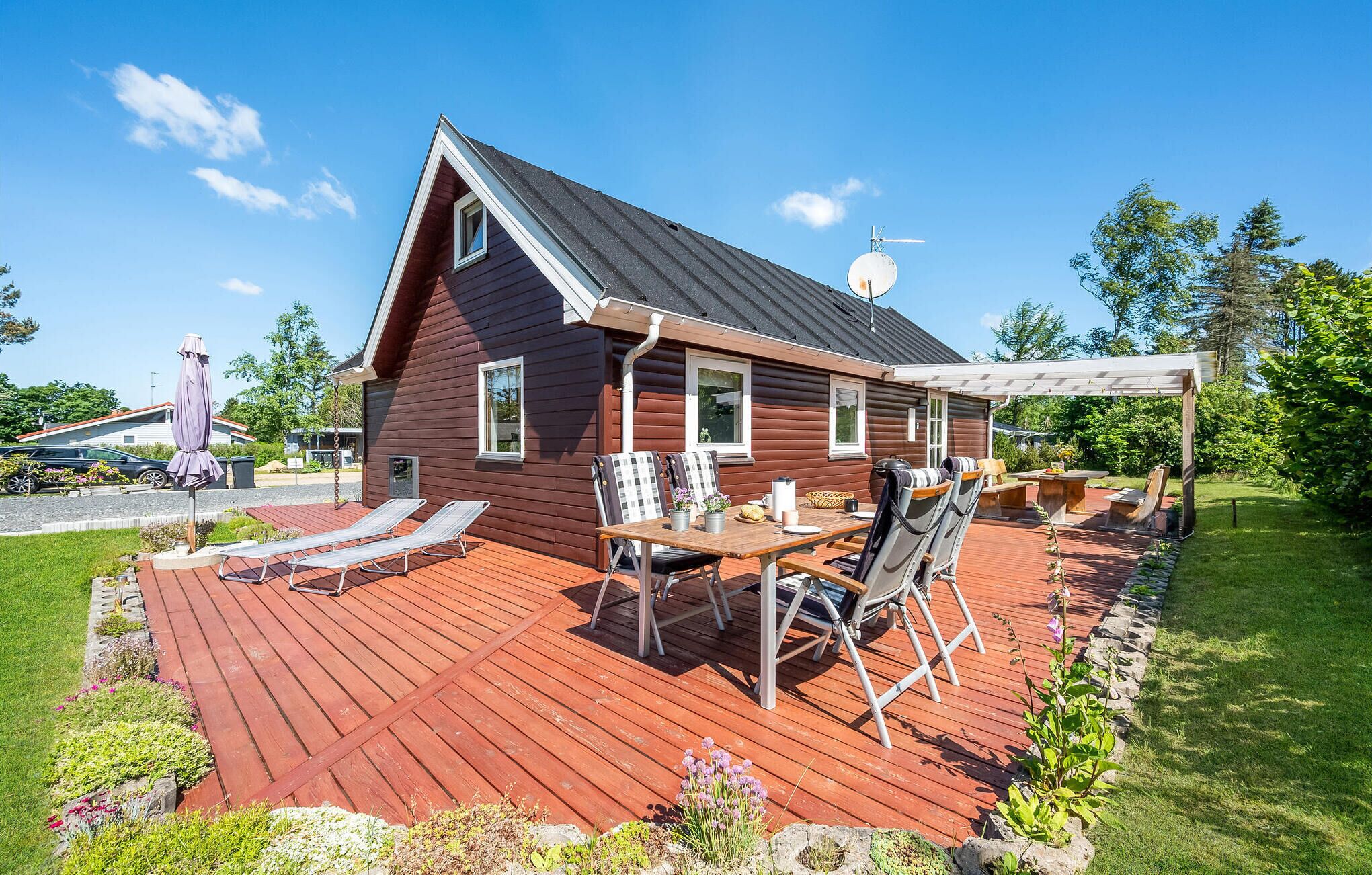 Une cabane en bois dotée d’une terrasse, d’un espace salon extérieur et d’un patio couvert.