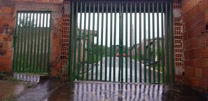 A gated entrance with a brick wall and a metal gate.