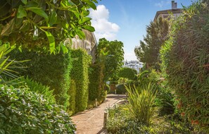 Stroll through the beautifully maintained garden, lined with lush greenery and traditional architecture.