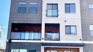 Un immeuble moderne à plusieurs étages, doté d’un garage, de grandes fenêtres et d’un parking.