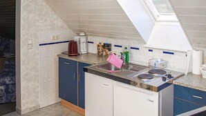 A compact kitchen with a built-in dishwasher, a coffee maker, and a kettle on the counter. - Nice apartment in Rankwitz/ OT Suckow with sauna (Rankwitz/ OT Suckow)