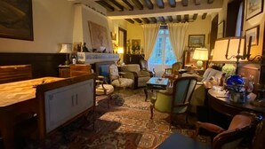 A cozy room with a wooden ceiling, a large rug, and a mix of furniture including a desk, chairs, and a sofa. - RIVERSIDE CHARACTER HOUSE WITH OUTBUILDING (Ménilles)