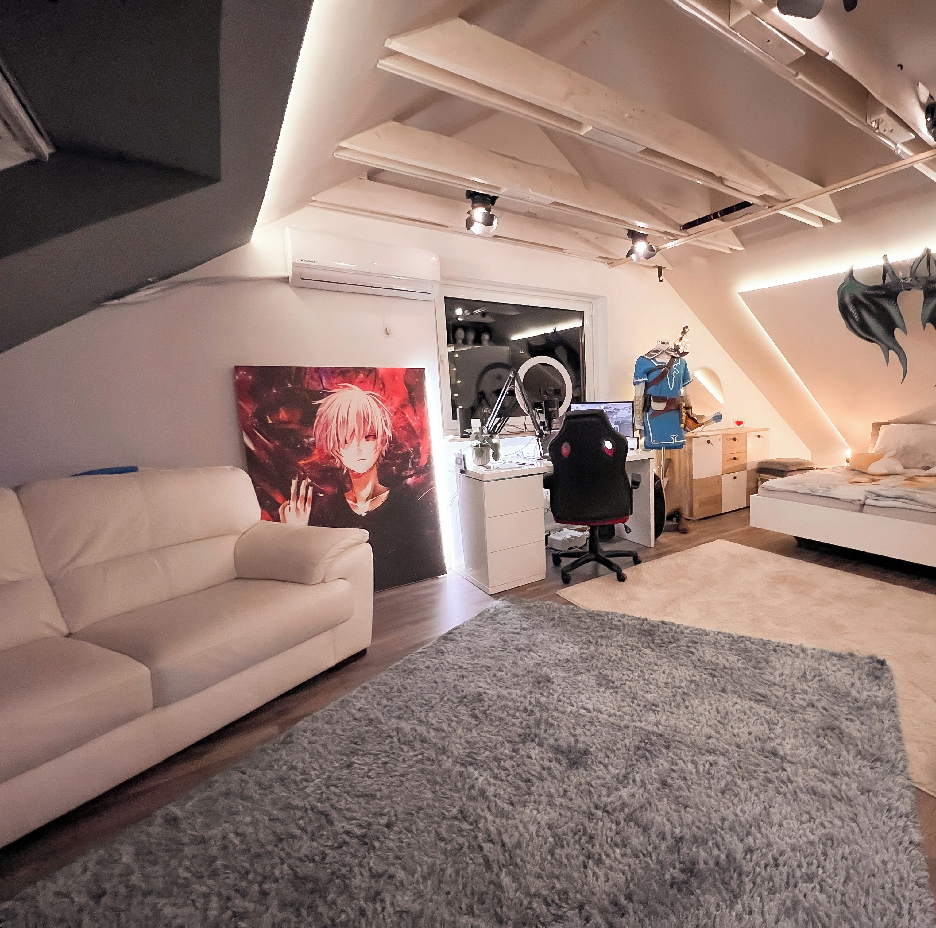 Ein modernes Schlafzimmer im Loft-Stil mit schrägem Dach, einem großen Bett, einem Schreibtisch und einem Gaming-Stuhl.