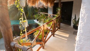 A wooden staircase with rope handrails, surrounded by potted plants and a thatched roof structure. - Arte Sano Hotel & Spa - Only Adults (Isla Holbox)