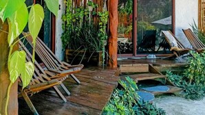 A wooden deck with lounge chairs, a pergola, and a thatched roof structure. - Arte Sano Hotel & Spa - Only Adults (Isla Holbox)