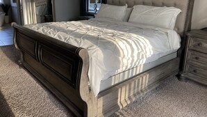 A bedroom with a large bed, a nightstand, a dresser, and a mirror. - Gorgeous Heated Pool Home Built in 2020 with Jacuzzi- 5.3 mi from INTL Airport…  (Jacksonville)