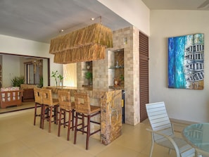 A bar area with wicker chairs and a thatched ceiling light fixture. - Casa Macabi  -  Yucatan Home Rentals (Chicxulub Puerto)