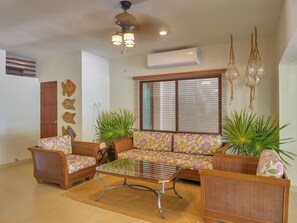 A living room with a sofa set, a coffee table, and decorative plants. - Casa Macabi - Yucatan Home Rentals (Chicxulub Puerto)