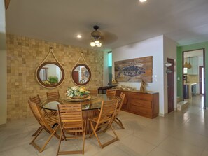 A dining area with a round table, wooden chairs, and a decorative centerpiece. - Casa Macabi - Yucatan Home Rentals (Chicxulub Puerto)