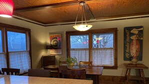 A dining area with a granite table, wooden chairs, a hanging light fixture, and a poster on the wall. - Historic and unique home on the hill, blocks away from the Marietta Square. (Marietta)