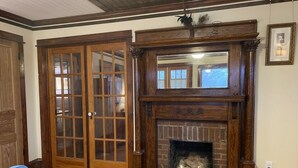 A room with a fireplace, wooden doors, and a blue chair. - Historic and unique home on the hill, blocks away from the Marietta Square. (Marietta)