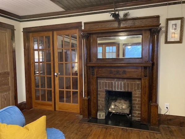A room with a fireplace, wooden doors, and a blue chair. - Historic and unique home on the hill, blocks away from the Marietta Square. (Marietta)
