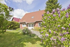 Ein Ziegelhaus mit rotem Ziegeldach, einer Haustür und einem kleinen Fenster.