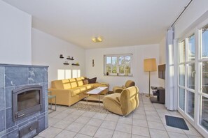 Ein Wohnzimmer mit Kamin, einer Couch, einem Couchtisch und einer Lampe.
