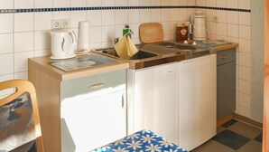 A compact kitchen with a sink, a coffee maker, a kettle, and a roll of paper towels. - Stunning apartment in Rankwitz/ OT Suckow (Rankwitz/ OT Suckow)