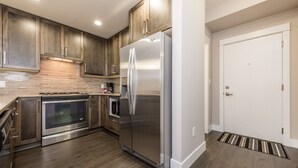 A modern kitchen with wooden cabinets, stainless steel appliances, and a tiled backsplash. - 3 Bedroom 2 Bath (Poway)