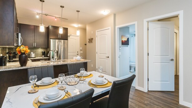 A modern kitchen with dark cabinets, stainless steel appliances, and pendant lighting. - 3 Bedroom 2 Bath (Poway)