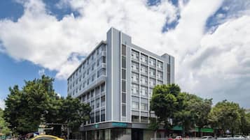 A modern building with a flat facade, multiple windows, and a visible entrance.