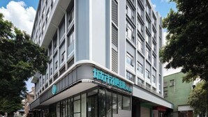 Un edificio moderno con fachada curva, ventanas grandes y un letrero que indica que es un hotel.