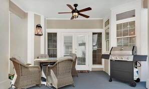 An outdoor patio with wicker furniture, a ceiling fan, and a grill.