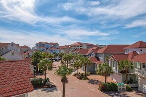 Zona residencial com casas de telhado vermelho e palmeiras.