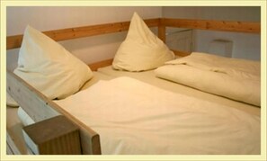 Simple, functional space with a bed and a plain headboard.
