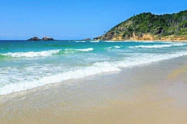 Enjoy a serene beach experience with gentle waves lapping at the shore.