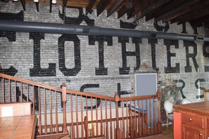 Een kamer met een bakstenen muur waarop grote, zwarte letters 