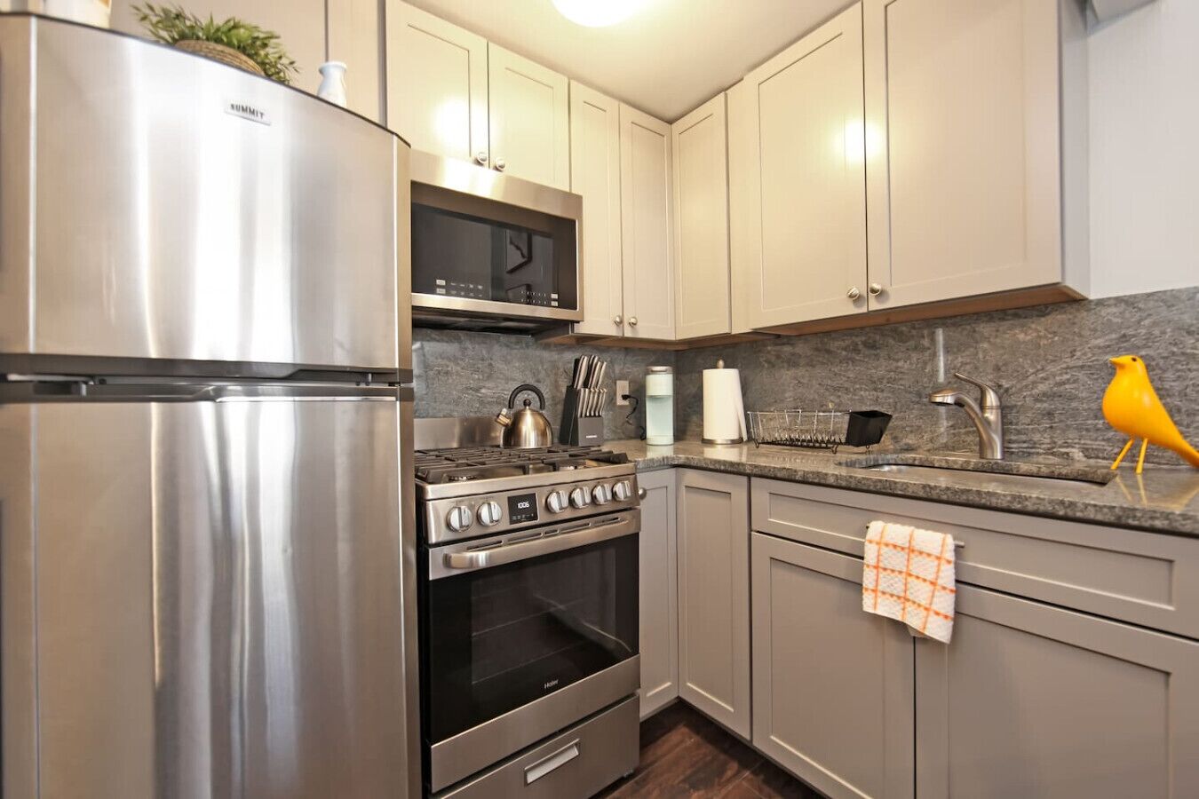 A modern kitchen with stainless steel appliances, a microwave, and a gas stove.