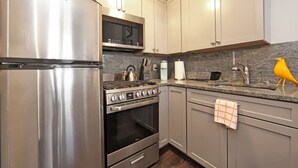 Una cocina moderna con electrodomésticos de acero inoxidable, microondas y cocina a gas.