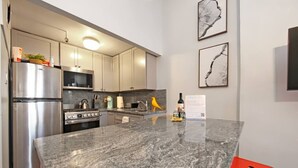 Una cocina moderna con electrodomésticos de acero inoxidable, encimeras de granito y armarios de diseño minimalista.