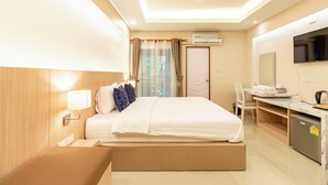 Une chambre d’hôtel équipée d’un lit, d’une table de chevet, d’un bureau et d’une télévision.