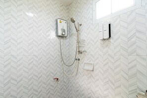 Une douche équipée d’un pommeau de douche à main, d’un autre pommeau de douche à main et d’un pommeau de douche fixé au mur.
