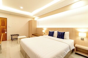 A modern hotel room with a large bed, bedside tables, a bench, and a wardrobe. - Tree Place by Zuzu (Bangkok)