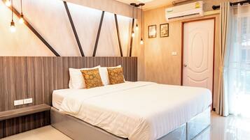 Un dormitorio moderno con una cama grande, paneles de madera en las paredes y un banco empotrado.