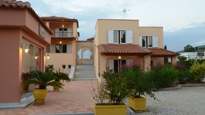 A multi-story building with a brick pathway leading to the entrance. There are potted plants and a small archway at the entrance. - Studio for 2 Guests (Nafplio)
