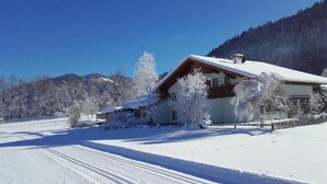 A snow-covered landscape with a house, trees, and mountains in the background. - Room-holiday Home Kahr Apartment Roßbran (Radstadt)