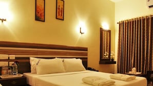 A hotel room with a large bed, two bedside tables, a nightstand, and a mirror.