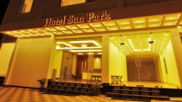 A hotel entrance with a sign reading 'Hotel Sun Park' and a checkered floor pattern.