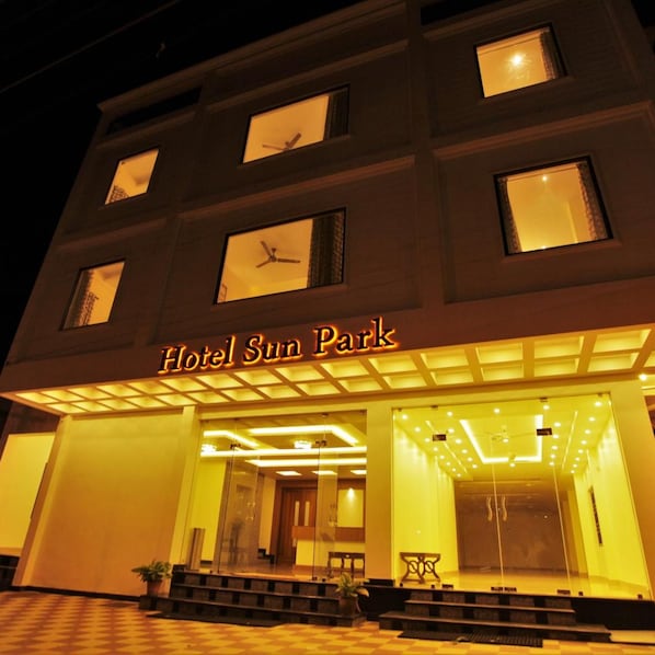 A hotel entrance with a sign reading 'Hotel Sun Park' and a checkered floor pattern.