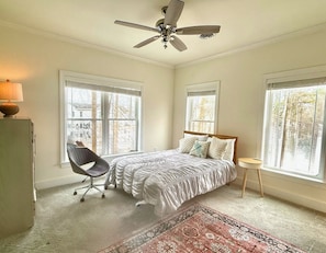 A bedroom with a bed, a desk, a chair, a ceiling fan, and large windows. - Bright beach house w/ Private Pool on Trolley loop (Bethany Beach)