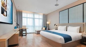 A hotel room with a large bed, a desk, a chair, and a window with curtains. - Echarm Hotel Liuzhou Liunan Wanda Plaza (Liuzhou)